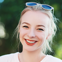 Smiling woman with traditional orthodontics